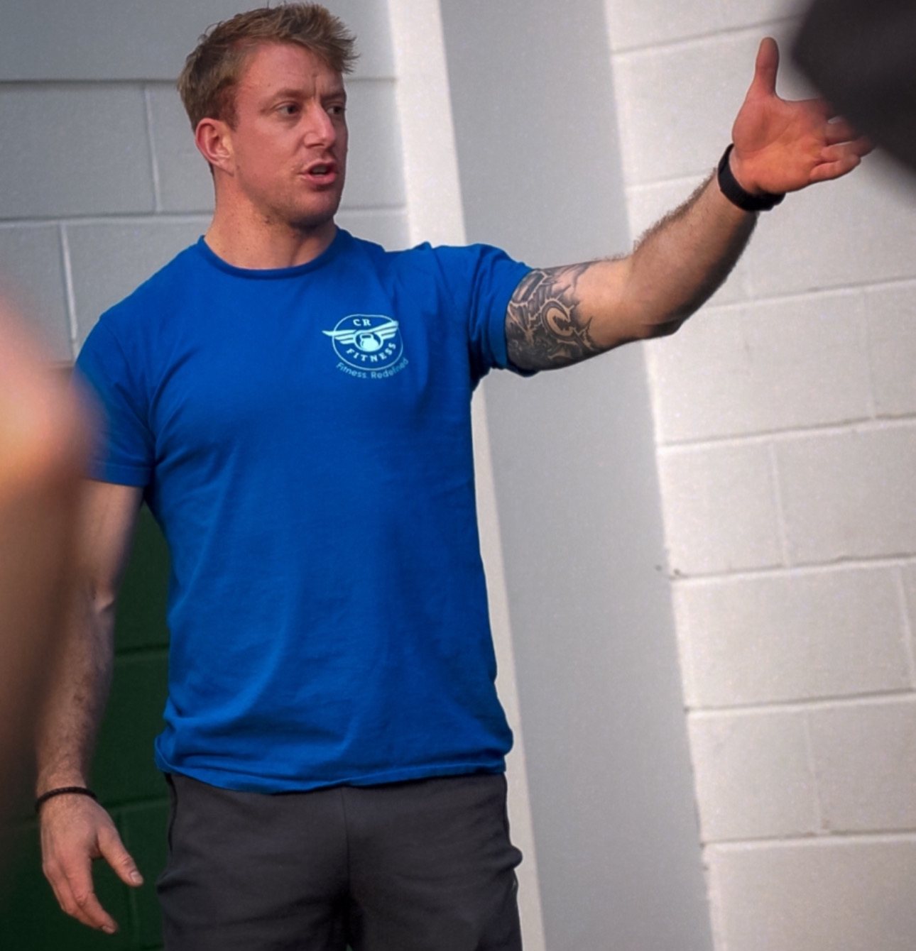 Coach Rob in a CR Fitness shirt, mid-instruction in the gym